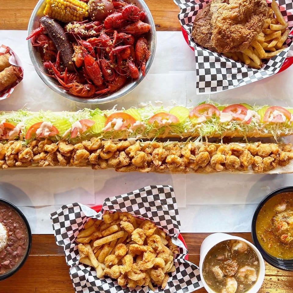 A feast of Cajun dishes, including crawfish boil, fried shrimp po'boy, and gumbo.
